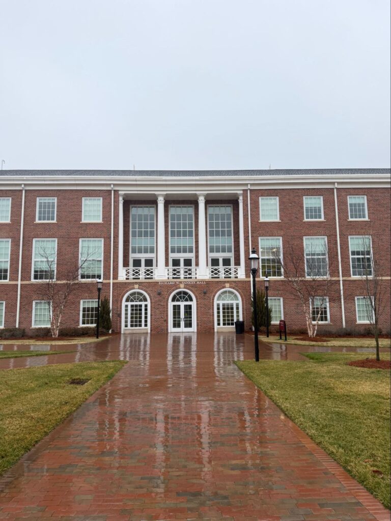Brick building with white columns and windows.